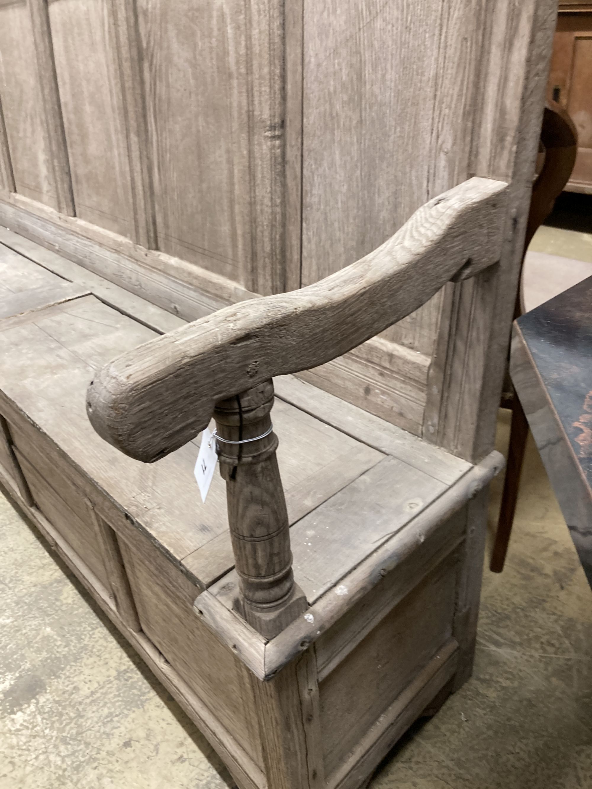 An 18th century bleached oak panelled box seat settle, length 206cm, depth 41cm, height 145cm